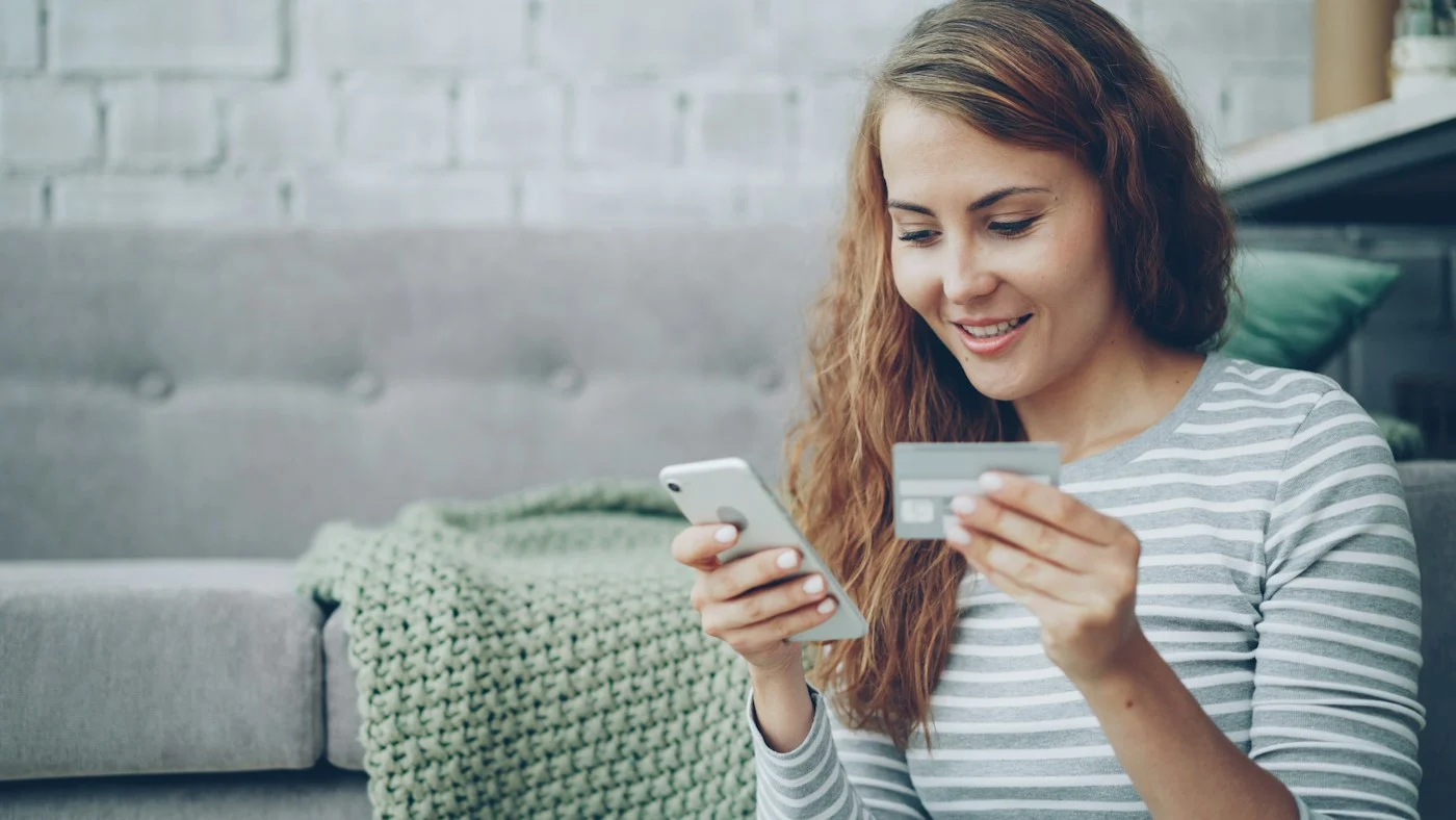 Vrouw betaalt met smartphone en betaalpas